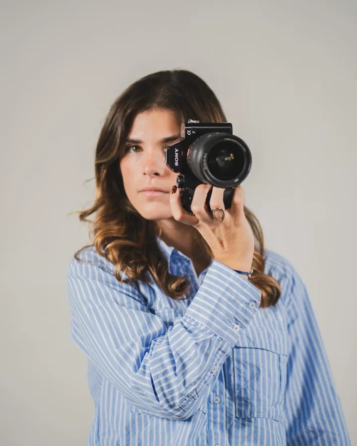 Angèle Octobon cadre une photo, l'appareil à l'œil