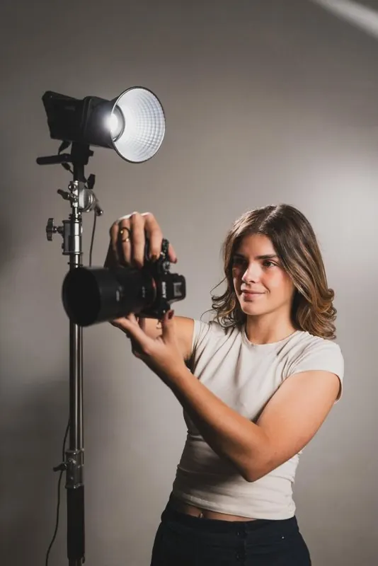 Angèle règle son appareil à côté d'une lampe de studio
