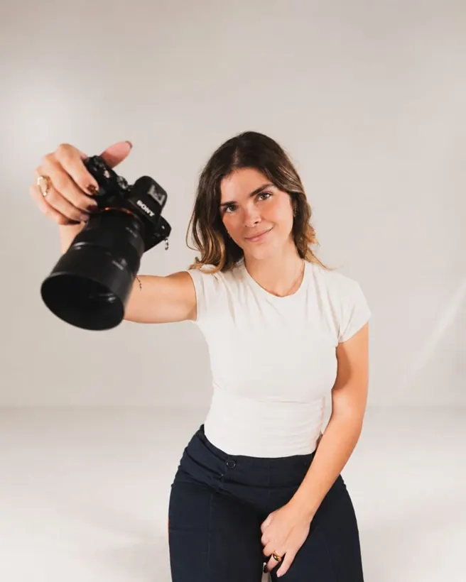 Angèle Octobon tend son appareil photo en souriant